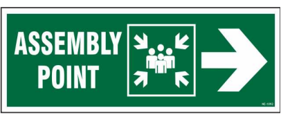Green ASSEMBLY POINT sign with an assembly symbol and right-pointing arrow by Safe Cure