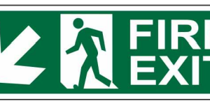 Green FIRE EXIT sign with a running-person symbol and diagonal downward-left arrow by Safe Cure