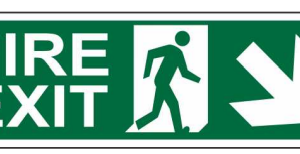 Green FIRE EXIT sign with a running-person symbol and diagonal downward-right arrow by Safe Cure