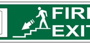 Green FIRE EXIT sign showing a person ascending stairs toward an exit door on the left
