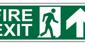 Green FIRE EXIT sign with a running-person symbol and upward arrow by Safe Cure
